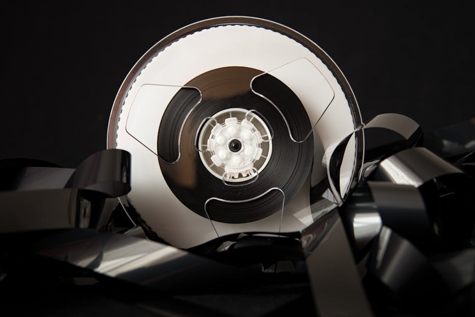 Warum jetzt der perfekte Zeitpunkt ist, Ihre Super-8-Filme zu digitalisieren: Vintage plastic bobbin with unrolled film for cinematography industry placed on black background Vintage Plastic Bobbin With Unrolled Film For Cinematography Industry Placed On Black Background